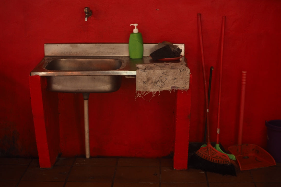 Red room with stainless steel sink and cleaning tools