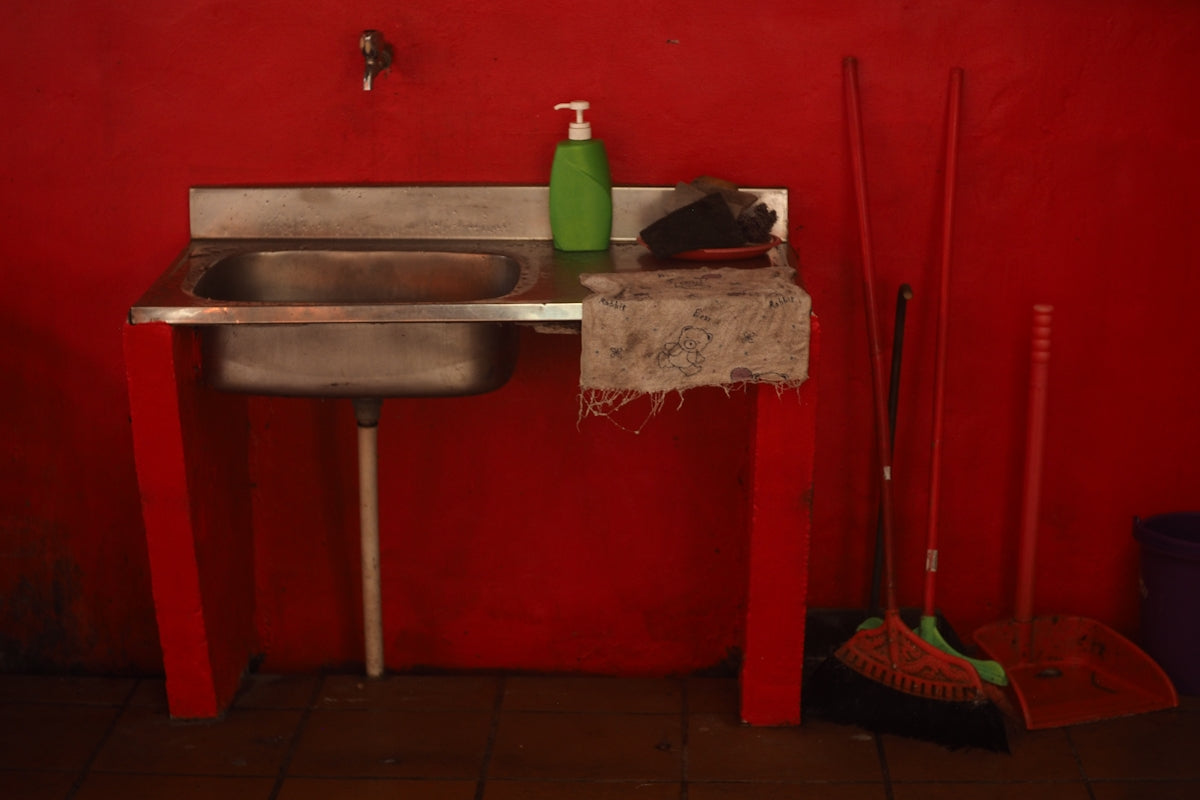 Red room with stainless steel sink and cleaning tools